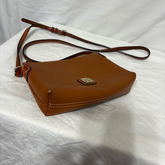 Dooney & Bourke Pebble Grain Crossbody Pouchette bag in a burnt orange color. - Picture 5 of 13